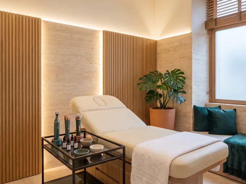 Sala de estética com maca, toalha branca e luz suave