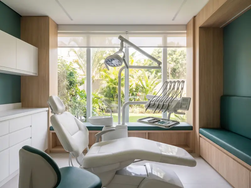 Consultório odontológico moderno e vazio, com cadeira e luz natural